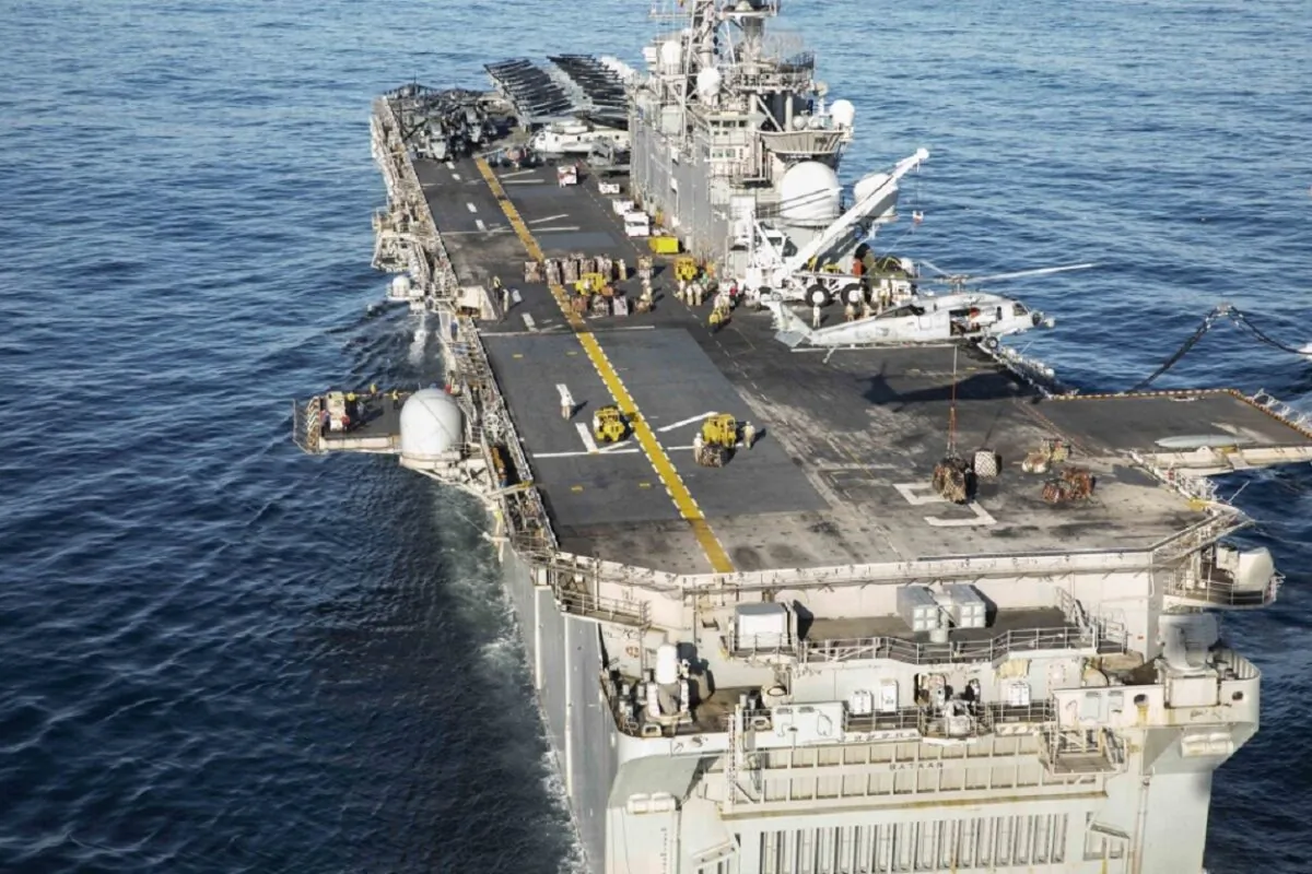 An MH-60S Sea Hawk, assigned to the Dragon Whales of Helicopter Sea Combat Squadron (HSC) 28, places cargo on the flight deck of the Wasp-class amphibious assault ship USS Bataan (LHD5), during a vertical replenishment between Bataan and the dry cargo and ammunition ship USNS William McLean (T-AKE 12) on Dec. 31, 2019. (U.S. Navy photo by Mass Communication Specialist 1st Class Kathryn E. Macdonald)