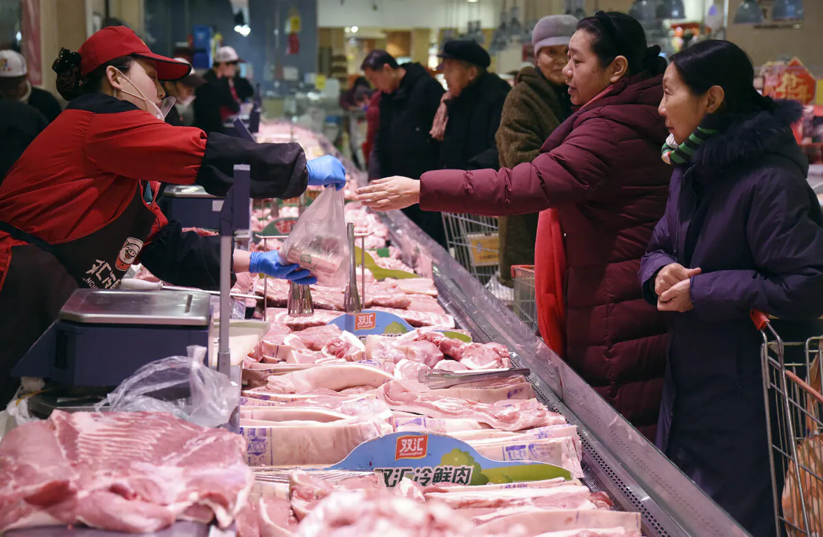 People shop for meat at a supermarket in Handan in northern China's Hebei Province on Jan. 9, 2020. Soaring pork prices that nearly doubled in December over a year ago kept inflation at a seven-year high despite government efforts to ease meat shortages caused by a disease outbreak. (Chinatopix via AP)