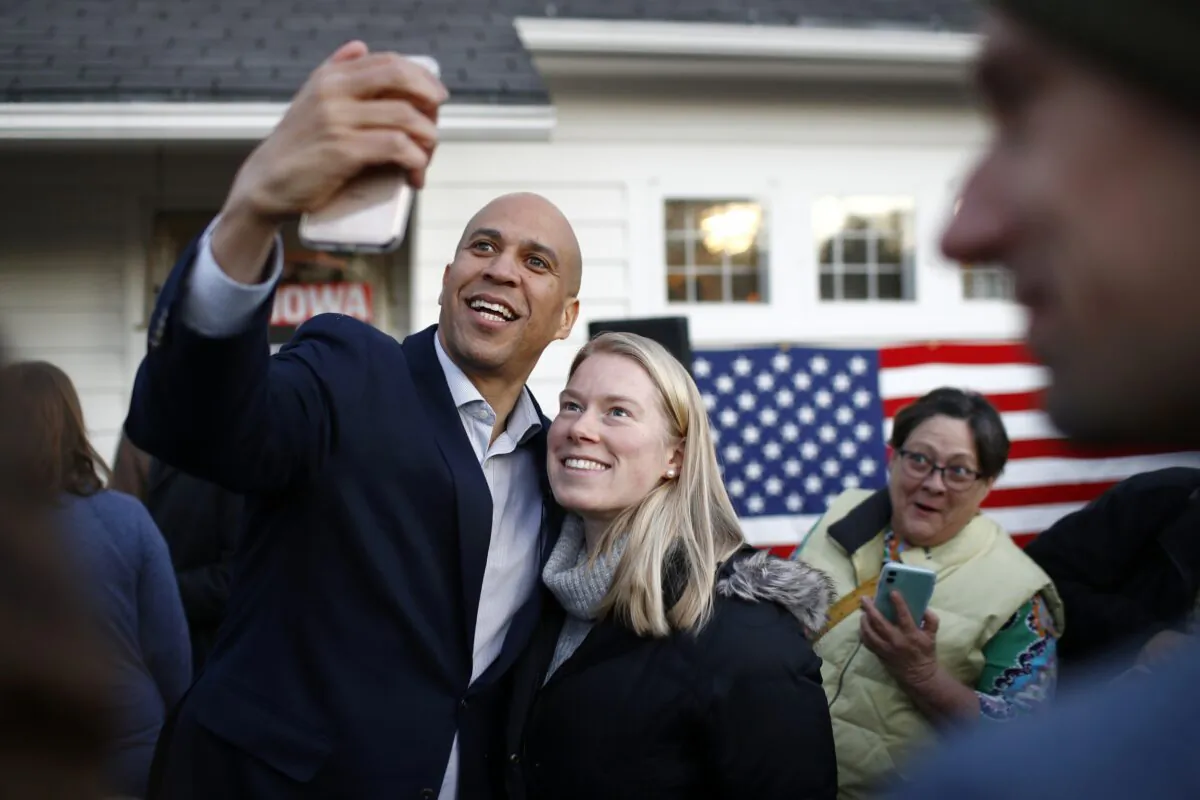 Democratic presidential candidate Sen. Cory Booker (D-N.J.) poses for a selfie with an attendee after speaking at a campaign event at the home of Polk County Democratic Chair Sean Bagniewski in Des Moines, Iowa, on Jan. 7, 2020. (Patrick Semansky/AP Photo)