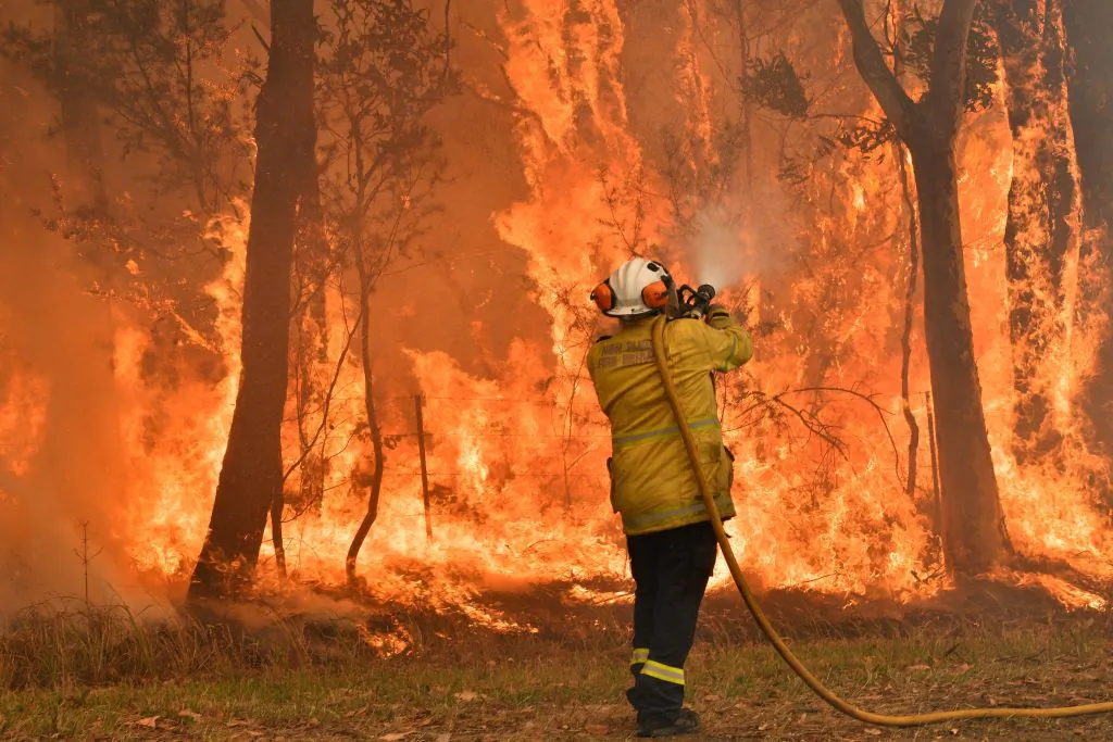 A firefighter conducts back-burning measures to secure residential areas from encroaching bushfires in the Central Coast, some 90-110 kilometres north of Sydney on Dec. 10, 2019. Toxic haze blanketed Sydney on Dec. 10 triggering a chorus of smoke alarms to ring across the city, as Australians braced for "severe" weather conditions expected to fuel deadly bush blazes. (Saeed Khan/via Getty Images)
