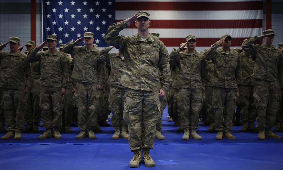 U.S. Army soldiers salute during the playing of the Star Spangled Banner during a homecoming ceremony in the Natcher Physical Fitness Center on Fort Knox, Ky., on Feb. 27, 2014. (Luke Sharrett/Getty Images)