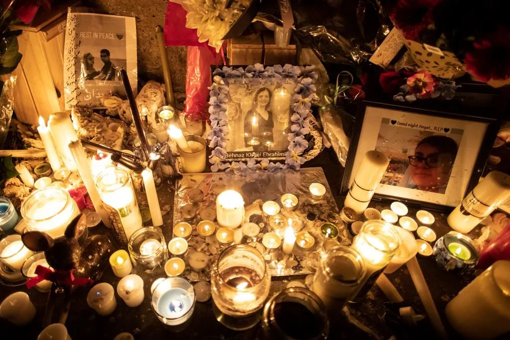 Photographs are left among candles at a memorial during a vigil in Toronto on Jan. 9, 2020, to remember the victims of the Iranian air crash. (The Canadian Press/Chris Young)