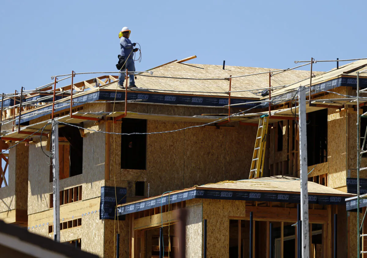 A worker walks on the roof of a new home under construction in Carlsbad, Calif., on Sept. 22, 2014. (Reuters/Mike Blake)