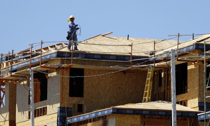 A worker walks on the roof of a new home under construction in Carlsbad, Calif., on Sept. 22, 2014. (Reuters/Mike Blake)