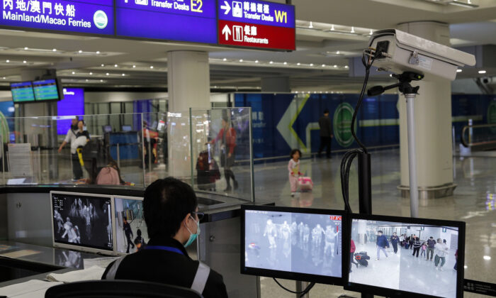 A health surveillance officer monitors passengers arriving at the Hong Kong International airport on Jan. 4, 2020. (AP Photo/Andy Wong, File)