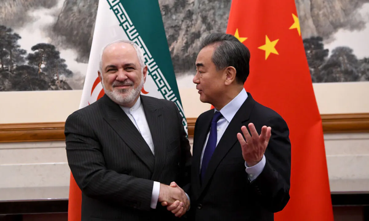 China’s Foreign Minister Wang Yi shakes hands with Iran’s Foreign Minister Mohammad Javad Zarif during a meeting in Beijing on Dec. 31, 2019.  (Noel Celis-Pool/Getty Images)