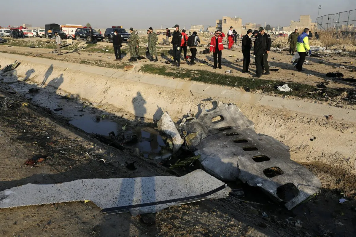 Debris is seen from an Ukrainian plane which crashed as authorities work at the scene in Shahedshahr, southwest of the capital Tehran, Iran on Jan. 8, 2020. (Ebrahim Noroozi/AP Photo)