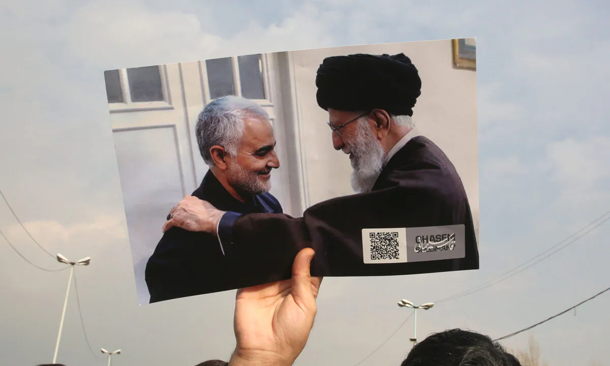 A man holds a picture of Iran's supreme leader Ayatollah Ali Khamenei (R) with Iranian Revolutionary Guards top commander Qassem Soleimani during a demonstration in Tehran on Jan. 3, 2020.  Atta Kenare/AFP via Getty Images