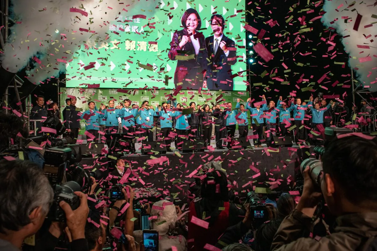 Confetti falls as Tsai Ing-Wen holds hands with Vice President-elect William Lai and Vice-President, Chen Chien-jen, as she celebrates after addressing supporters following her re-election as President of Taiwan in Taipei, Taiwan on January 11, 2020. (Carl Court/Getty Images)