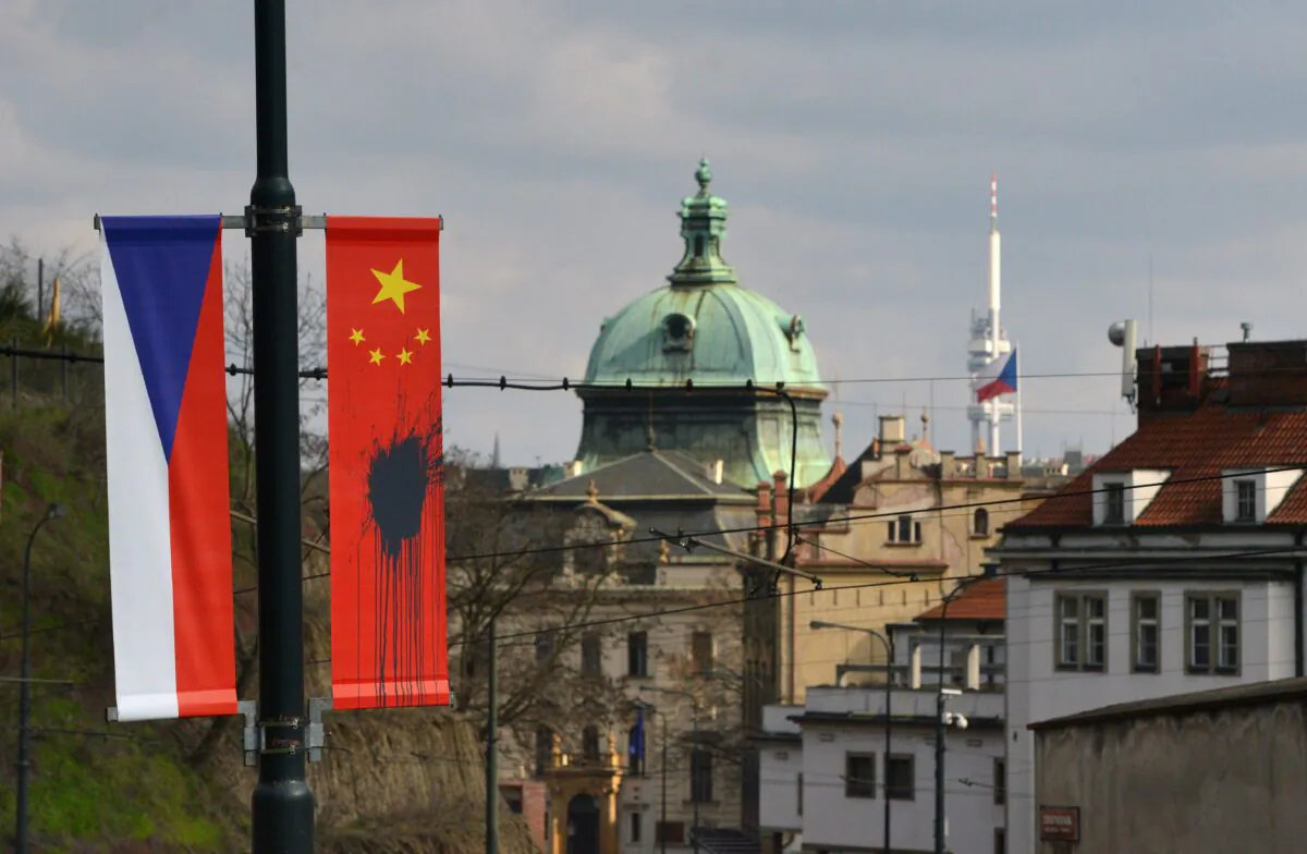 A Czech national flag hangs next to a Chinese national flag splattered with a black substance in Prague on March 26, 2016. (MICHAL CIZEK/AFP via Getty Images)
