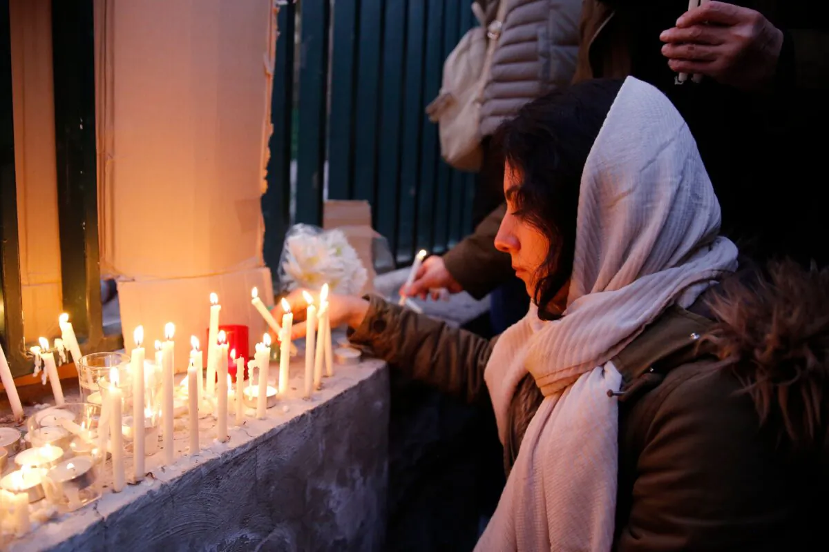 An Iranian lights candles for the victims of Ukraine International Airlines Boeing 737 during a gathering in front of the Amirkabir University in the capital Tehran, on Jan. 11, 2020. (AFP via Getty Images)