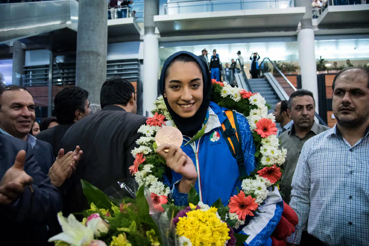 Kimia Alizadeh who became the first Iranian woman ever to win an Olympic medal, shows her medal upon her arrival at Imam Khomeini International Airport Tehran, on Aug. 26, 2016. (Peyman/AFP via Getty Images)