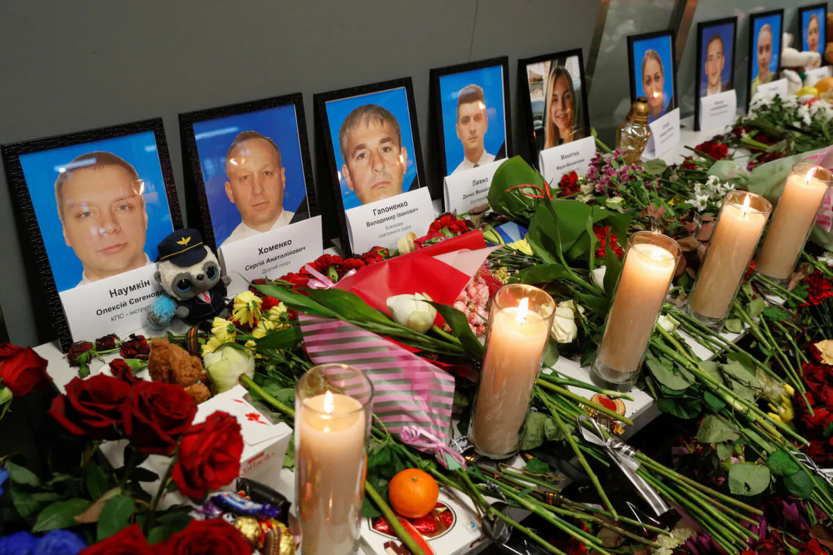 Flowers and candles are placed in front of the portraits of the flight crew members of the Ukraine International Airlines Boeing 737-800 plane that crashed in Iran, at a memorial at the Boryspil International Airport outside Kiev, Ukraine, on Jan. 11, 2020. (Valentyn Ogirenko/Reuters)