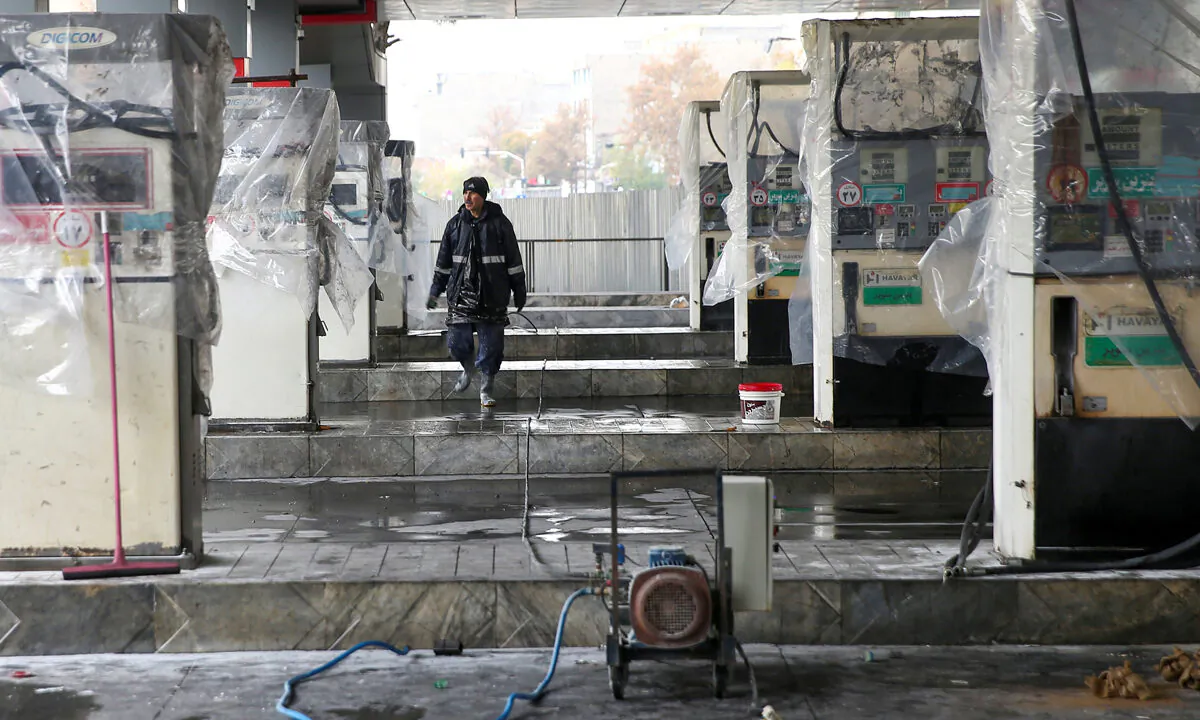 A man walks near the remains of gas pump stands, during protests against increased fuel prices, in Tehran, Iran, on Nov. 20, 2019. The Iranian regime curbed the internet before possible new protests. (Nazanin Tabatabaee/WANA via Reuters)