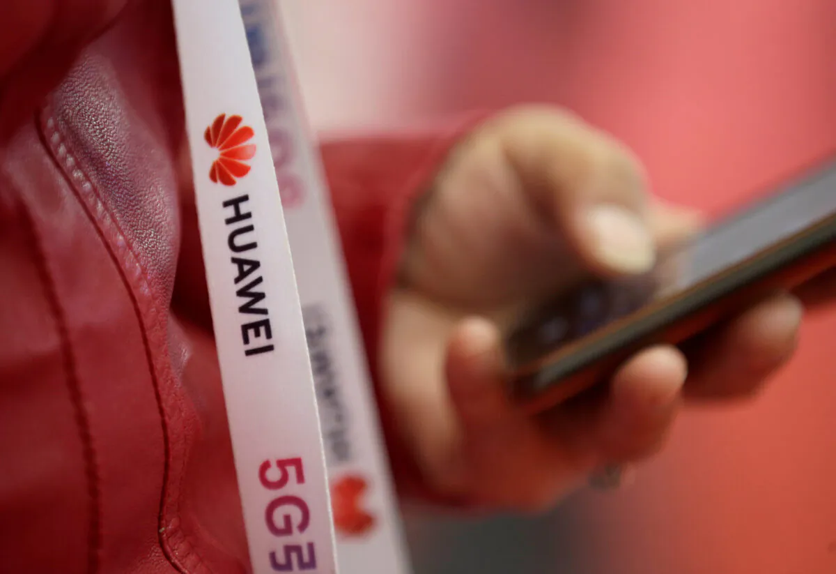 An attendee wears a badge strip with the logo of Huawei and a sign for 5G at the World 5G Exhibition in Beijing, China on Nov. 22, 2019. (Jason Lee/Reuters)