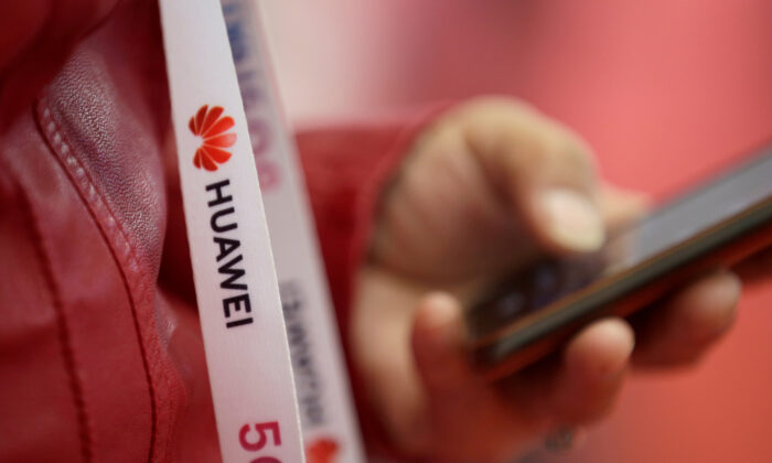 An attendee wears a badge strip with the logo of Huawei and a sign for 5G at the World 5G Exhibition in Beijing, China on Nov. 22, 2019. (Jason Lee/Reuters)