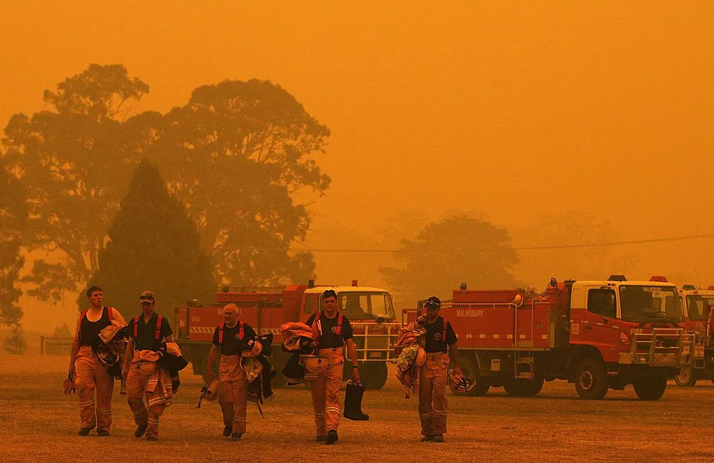 Firemen return to Briagolong base camp after battling bushfires on December 10, 2006 in Melbourne, Australia. Thirty-seven bushfires, thought to have been sparked by lightning, have joined together to become 15 large fires. They have burned approximately 90,000 hectares of scrub and forest and continue to spread in the southern Australian state of Victoria. Officials predict the fires might burn out as much as 600,000 hectares by next week. Several villages and properties are under threat from the advancing fire front. The Bureau of Meteorology expects temperatures to reach over 37 degrees Celcius on Saturday in the areas affected by the fire, making fire fighting extremely difficult.  (Photo by Quinn Rooney/Getty Images)