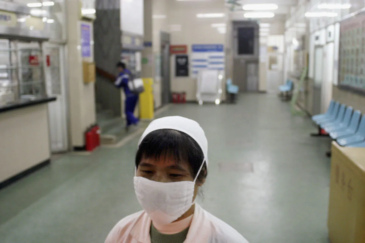 A nurse wearing a face mask, walks in a hallway of a hospital in Guangzhou, China on Jan. 13, 2004. (Getty Images)