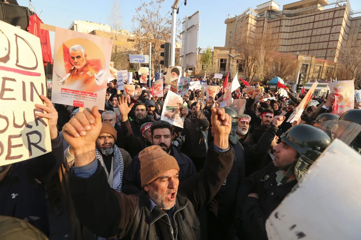 Iranian demonstrators hold placards bearing the image of slain military commander Qasem Soleimani in front of the British embassy in the capital Tehran on Jan. 12, 2020 following the British ambassador's arrest for allegedly attending an illegal demonstration. (Atta Kenare/AFP via Getty Images)