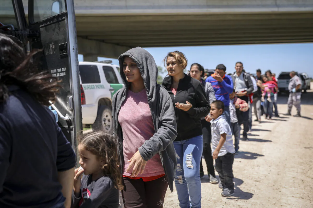 A large group of illegal aliens boards a bus bound for the Border Patrol processing facility after being apprehended by Border Patrol near McAllen, Texas, on April 18, 2019. (Charlotte Cuthbertson/The Epoch Times)