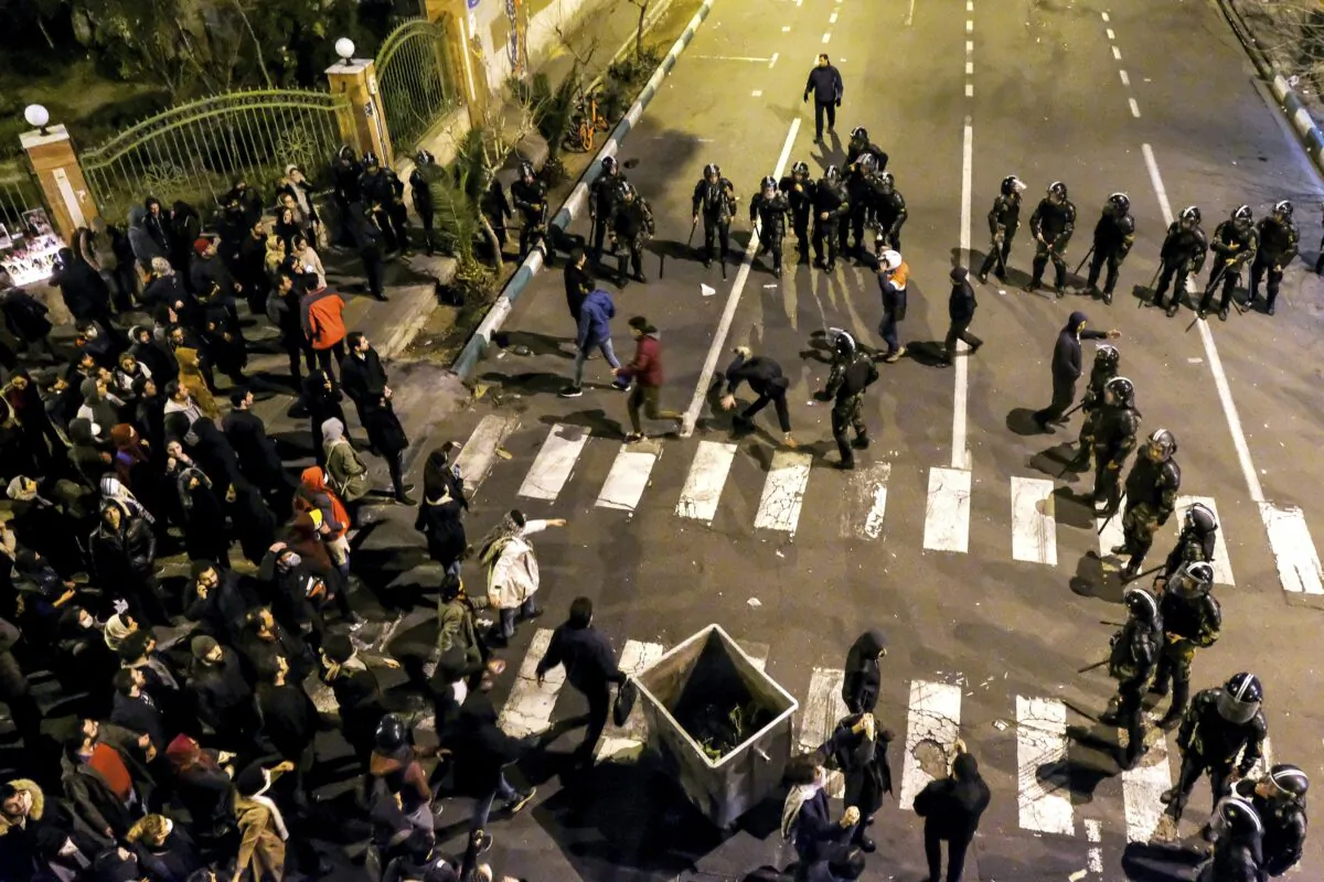 Iranian police officers take position while protesters gather in front of Amir Kabir University in Tehran, Iran, on Jan. 11, 2020. (AP Photo)