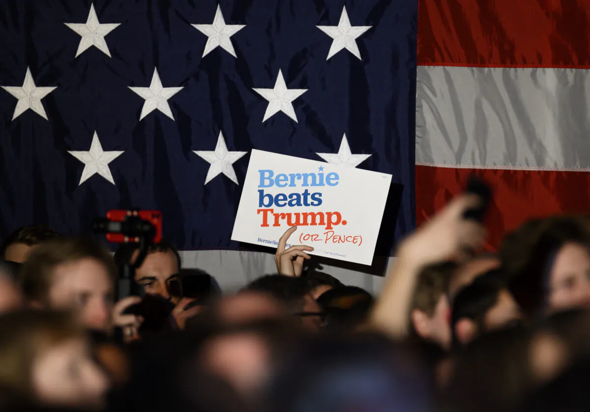 Supporters wave signs and hold up their phones as democratic presidential candidate Sen. Bernie Sanders (I-VT) speaks at a New Year's Eve campaign event on Dec. 31, 2019 in Des Moines, Iowa. (Stephen Maturen/Getty Images)