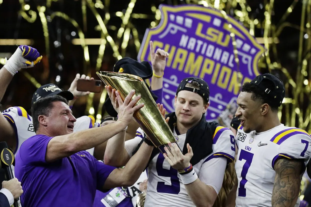 LSU head coach Ed Orgeron, left, and quarterback Joe Burrow, center, hold the trophy beside safety Grant Delpit after a NCAA College Football Playoff national championship game against Clemson on Jan. 13, 2020, in New Orleans. LSU won 42-25. (Sue Ogrocki/AP Photo)