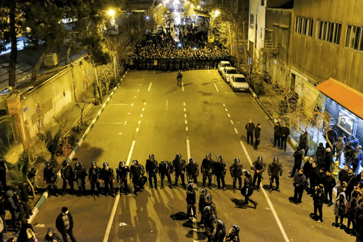 Iranian police officers take position while protesters gather in front of Amir Kabir University in Tehran, Iran, on Jan. 11, 2020. (AP Photo)