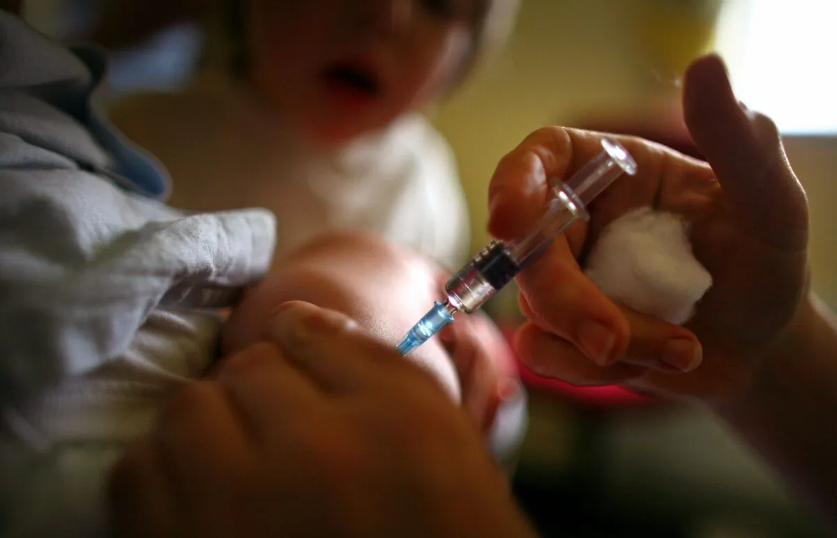 A young boy receives an immunization shot. (Jeff J. Mitchell/Getty Images)