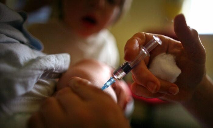 A young boy receives an immunization shot. (Jeff J. Mitchell/Getty Images)