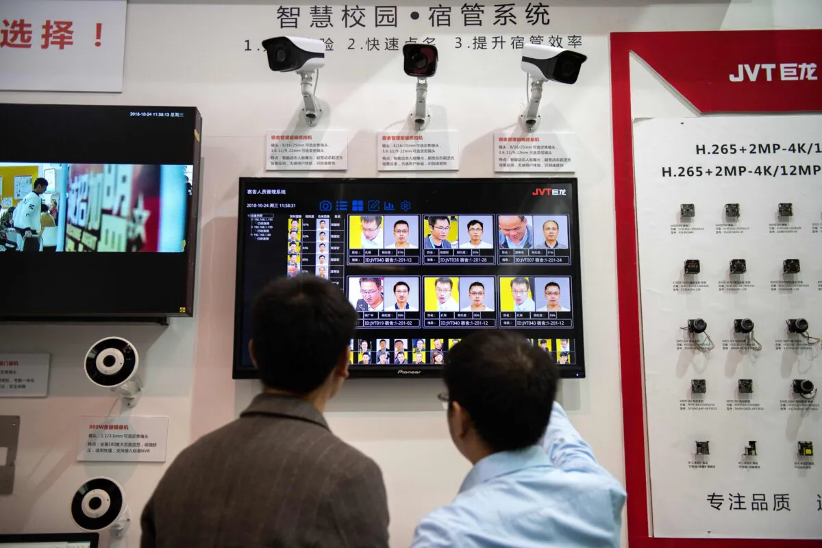 Visitors look at AI (artificial intelligence) security cameras with facial recognition technology at the 14th China International Exhibition on Public Safety and Security at the China International Exhibition Center in Beijing on Oct. 24, 2018. (Nicolas Asfouri/AFP via Getty Images)