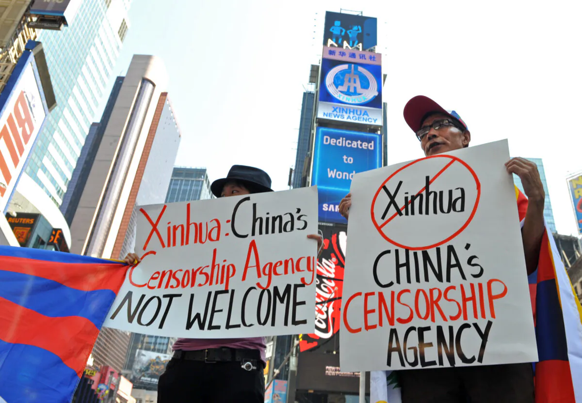 Students for a Free Tibet protest below a new electronic billboard leased by Xinhua (2nd from top), the news agency operated by the Chinese regime, as it makes its debut in New York's Times Square on Aug 1, 2011. (Stan Honda/AFP via Getty Images)
