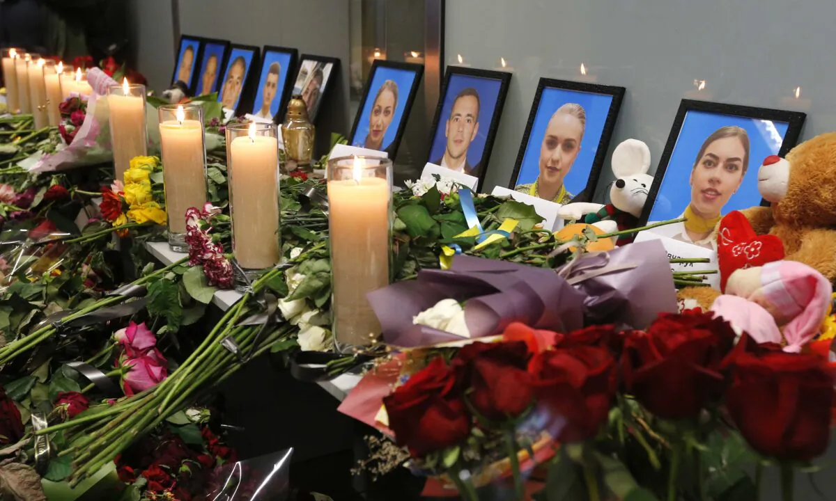 Flowers and candles are placed in front of portraits of the flight crew members of the Ukrainian 737-800 plane shot down by the Iranian military on the outskirts of Tehran, at a memorial inside Borispil international airport outside Kyiv, Ukraine, on Jan. 11, 2020.  (Efrem Lukatsky/AP Photo)