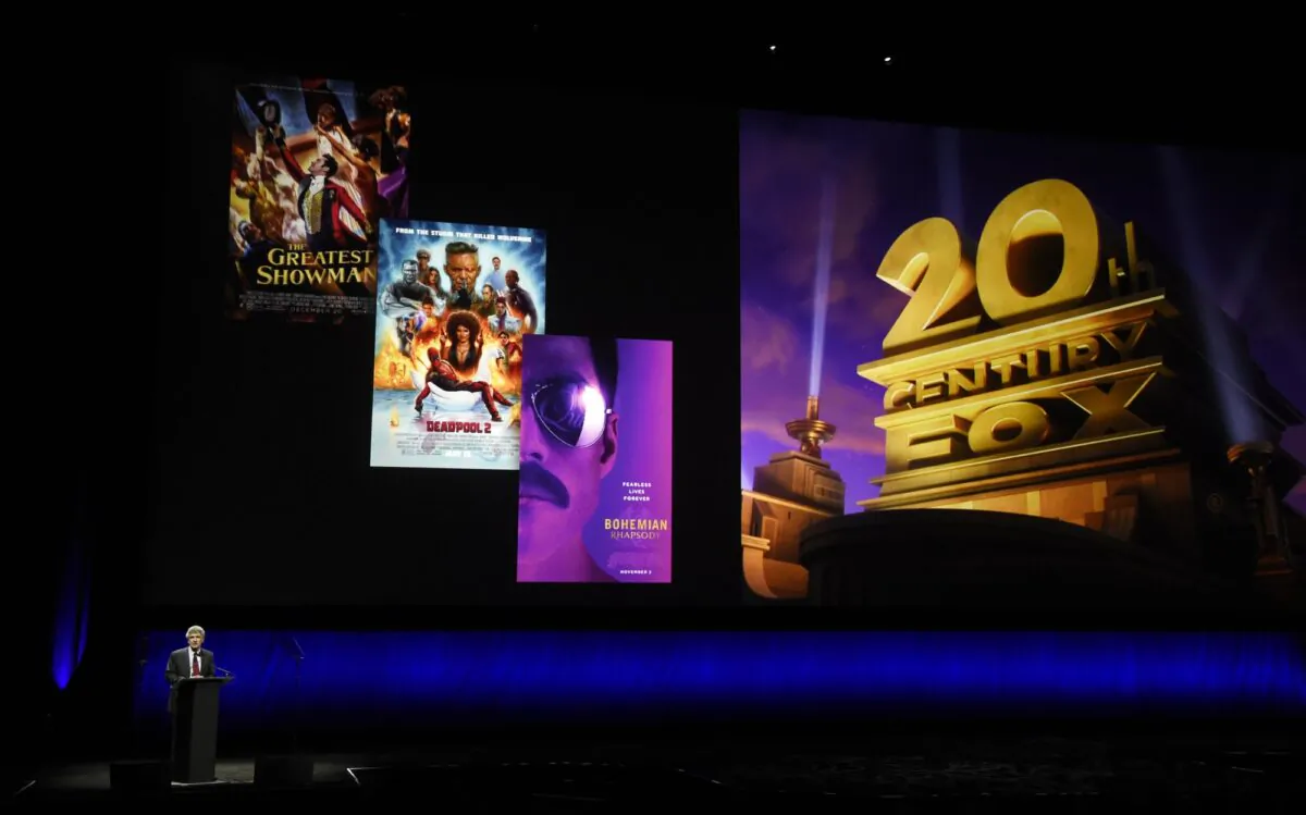 Alan Horn, chairman of The Walt Disney Studios, speaks underneath poster images for 20th Century Fox films during the Walt Disney Studios Motion Pictures presentation at CinemaCon 2019, the official convention of the National Association of Theatre Owners (NATO) at Caesars Palace in Las Vegas, Nev., on April 3, 2019. (Chris Pizzello/Invision/AP)