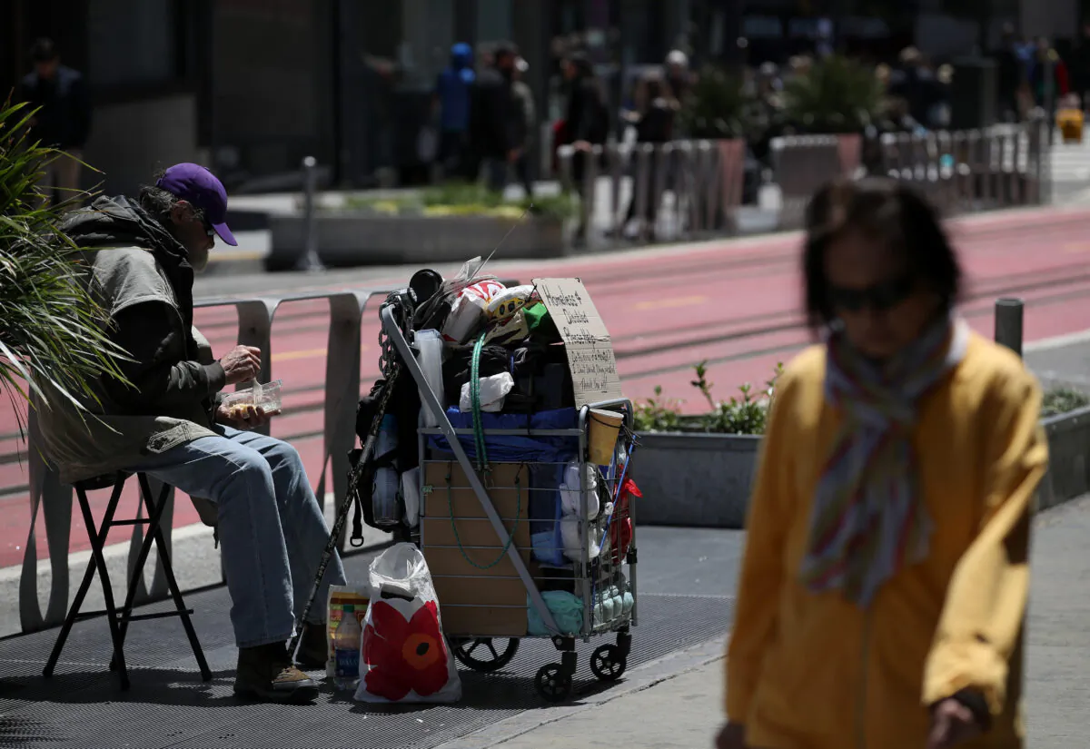 A pedestrian walks by a homeless man who is begging for money on May 17, 2019 in San Francisco, Calif. (Justin Sullivan/Getty Images)