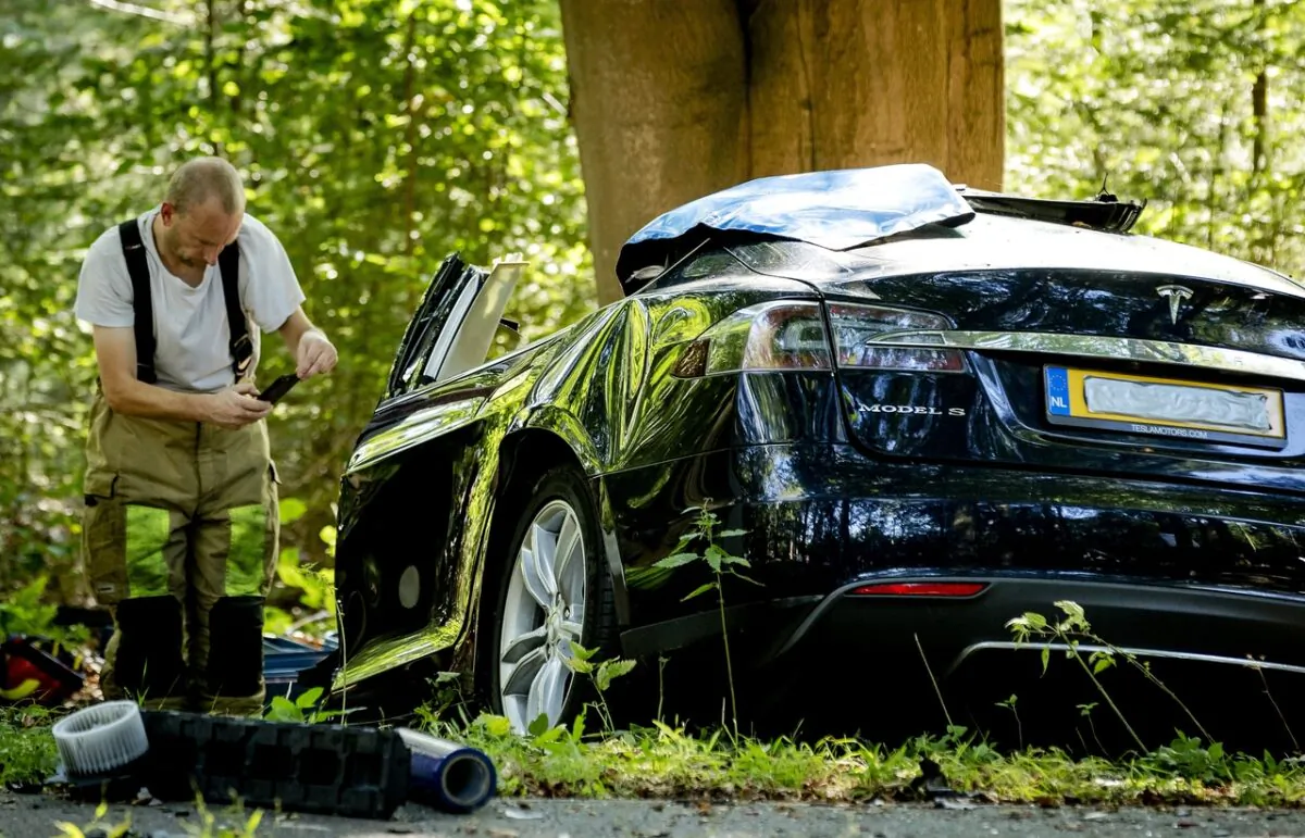 A rescue worker takes a picture after a fatal crash where a Tesla Model S struck a tree in Baarn, the Netherlands on Sept. 7, 2016. (Robin Van Lonkhuijsen/AFP via Getty Images)