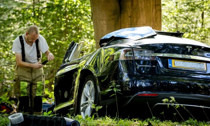 A rescue worker takes a picture after a fatal crash where a Tesla Model S struck a tree in Baarn, the Netherlands on Sept. 7, 2016. (Robin Van Lonkhuijsen/AFP via Getty Images)