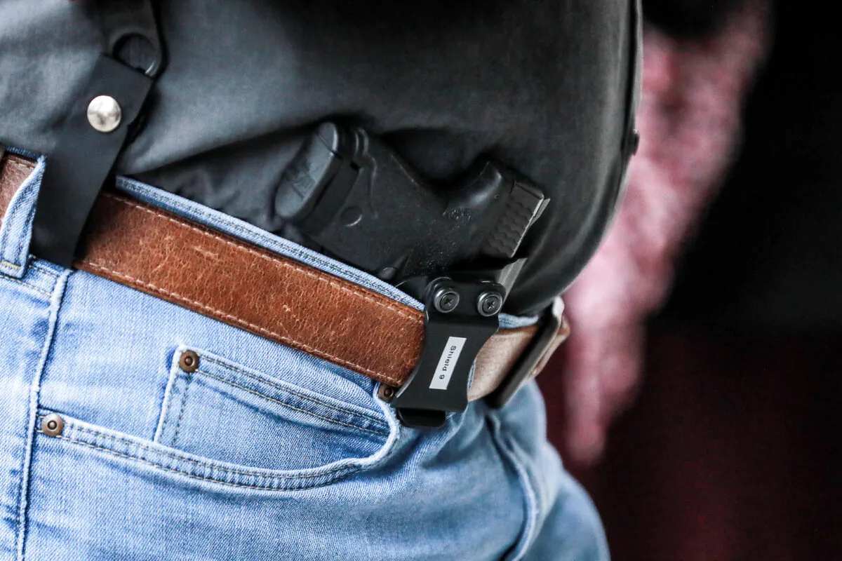 A man carries a gun before a hearing where four gun control bills passed the Senate Judiciary Committee at the Virginia State Capitol in Richmond, Va., on Jan. 13, 2020. (Samira Bouaou/The Epoch Times)