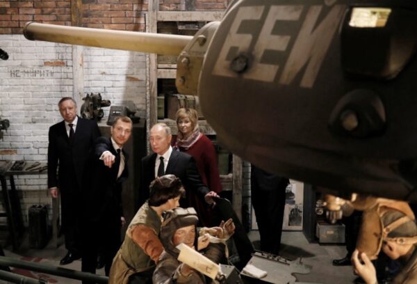 Russian President Vladimir Putin visits an exhibition depicting an armament repair shop