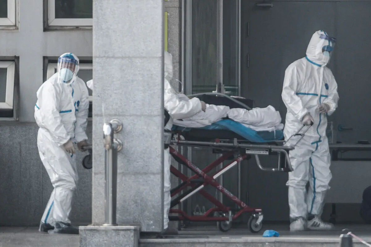 Medical staff members carry a patient into the Jinyintan hospital, where patients infected by a mysterious SARS-like viral pneumonia are being treated, in Wuhan in China's central Hubei province on January 18, 2020. (STR/AFP via Getty Images)