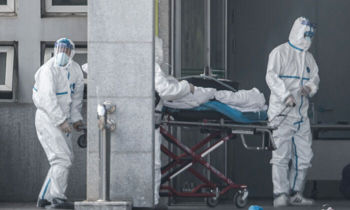 Medical staff members carry a patient into the Jinyintan hospital, where patients infected by a mysterious SARS-like viral pneumonia are being treated, in Wuhan in China's central Hubei province on January 18, 2020. (STR/AFP via Getty Images)