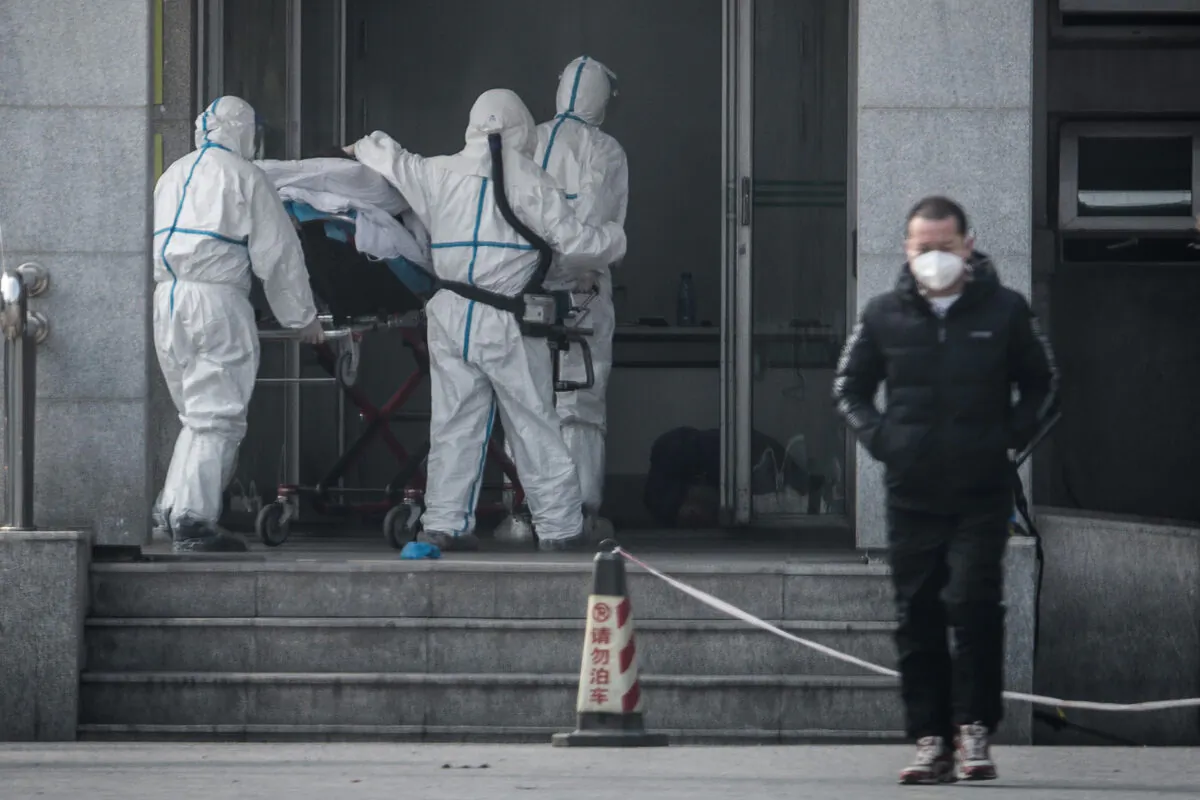 Medical staff members carry a patient into the Jinyintan hospital, where patients infected by a mysterious SARS-like virus are being treated, in Wuhan in China's central Hubei province on Jan. 18, 2020. (STR/AFP via Getty Images)