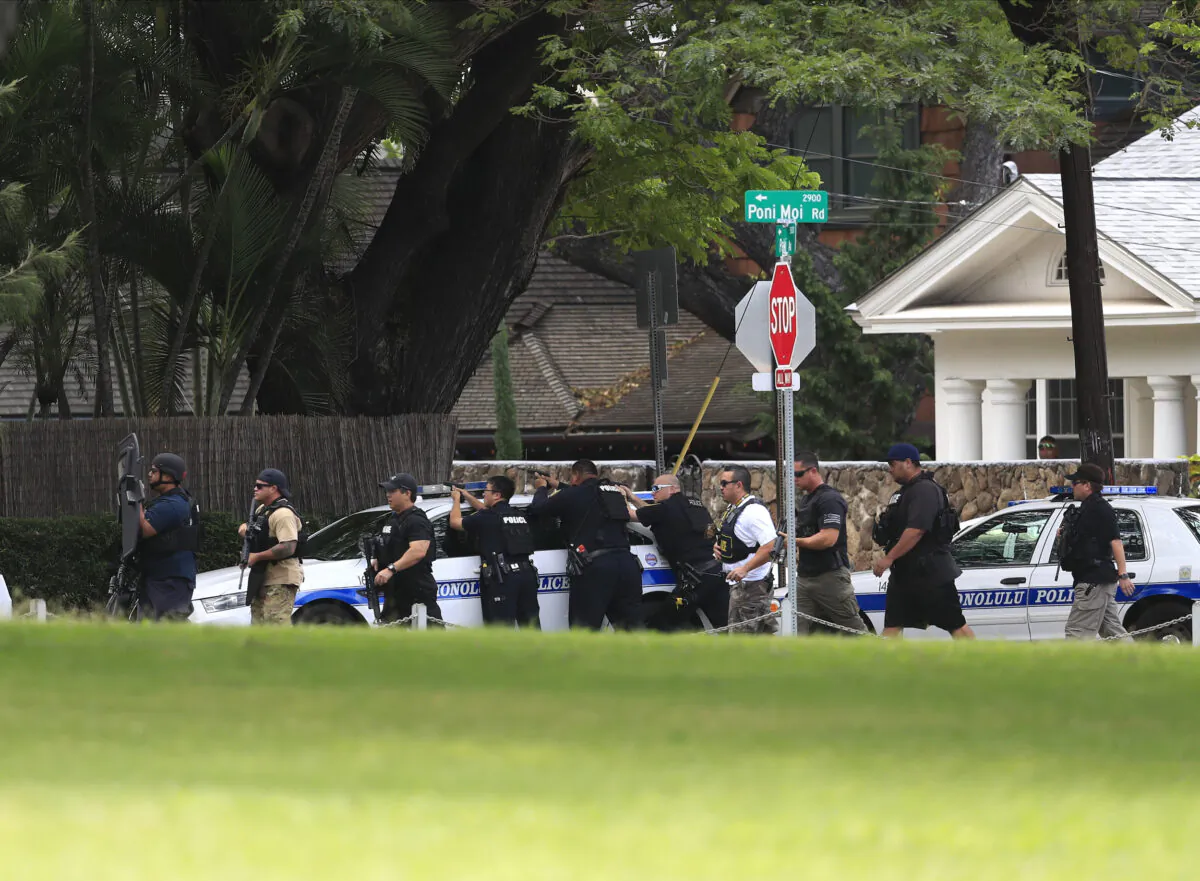 Honolulu police take up defensive positions with their weapons after a shooting and domestic incident at a residence on Hibiscus Road near Diamond Head in Honolulu, Hawaii, on Jan. 19, 2020. (Jamm Aquino/Honolulu Star-Advertiser)