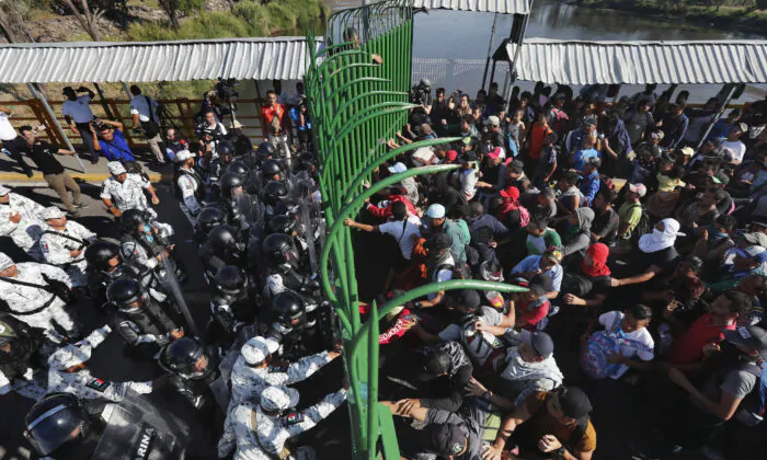 Migrants charge on the Mexican National Guardsmen at the border crossing between Guatemala and Mexico in Tecun Uman, Guatemala, on Jan. 18, 2020. (Marco Ugarte/AP Photo)