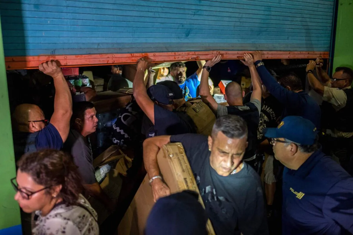 Police arrive as people break into a warehouse filled with supplies in Ponce, Puerto Rico, on Jan. 18, 2020. (Ricardo Arduengo/AFP/Getty Images)