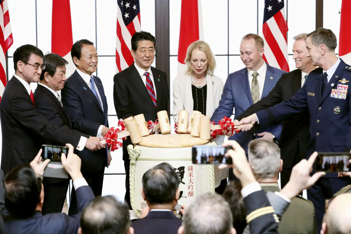Japanese Prime Minister Shinzo Abe (4th L), the granddaughter Mary Jean Eisenhower (4th R) and great grandson Merrill Eisenhower Atwater (3rd R) of former U.S. President Dwight Eisenhower, attend a sake barrel-breaking ceremony in the 60th anniversary commemorative reception of the signing of the Japan-US security treaty in Tokyo, Japan, on Jan. 19, 2020. (Kyodo/via Reuters)
