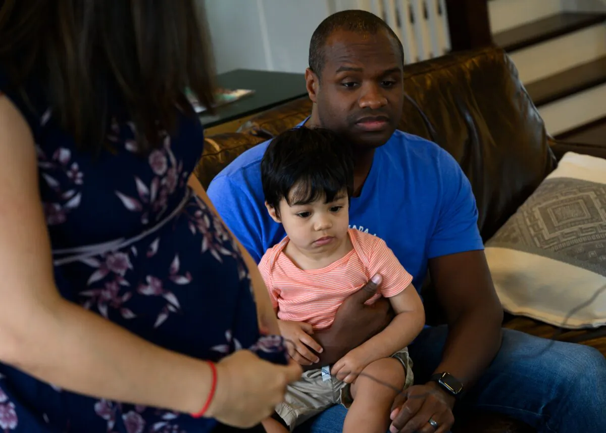 Cindy Luna (L) looks on as her husband Roby holds their son Mateo at her home in Herndon, Virginia on June 5, 2019. (ANDREW CABALLERO-REYNOLDS/AFP via Getty Images)