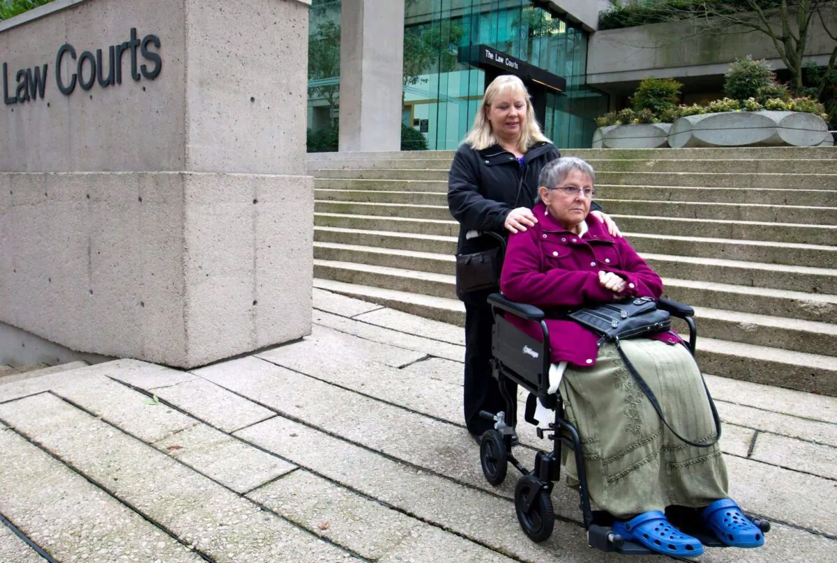 Gloria Taylor, assisted by her sister Patty Ferguson, pauses to talk to media outside the B.C. Supreme Court in Vancouver on Dec. 1, 2011. Taylor, who had Lou Gehrig's disease, was part of a legal battle to change the laws that criminalize doctor-assisted suicide. (The Canadian Press/Darryl Dyck)