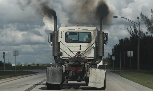 Smoke pours from the exhaust pipes on a truck
