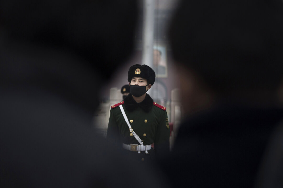 A Chinese paramilitary police officer wears a mask to protect against pollution, while marching during smog in Tiananmen Square in Beijing on Dec. 9, 2015. (Kevin Frayer/Getty Images)